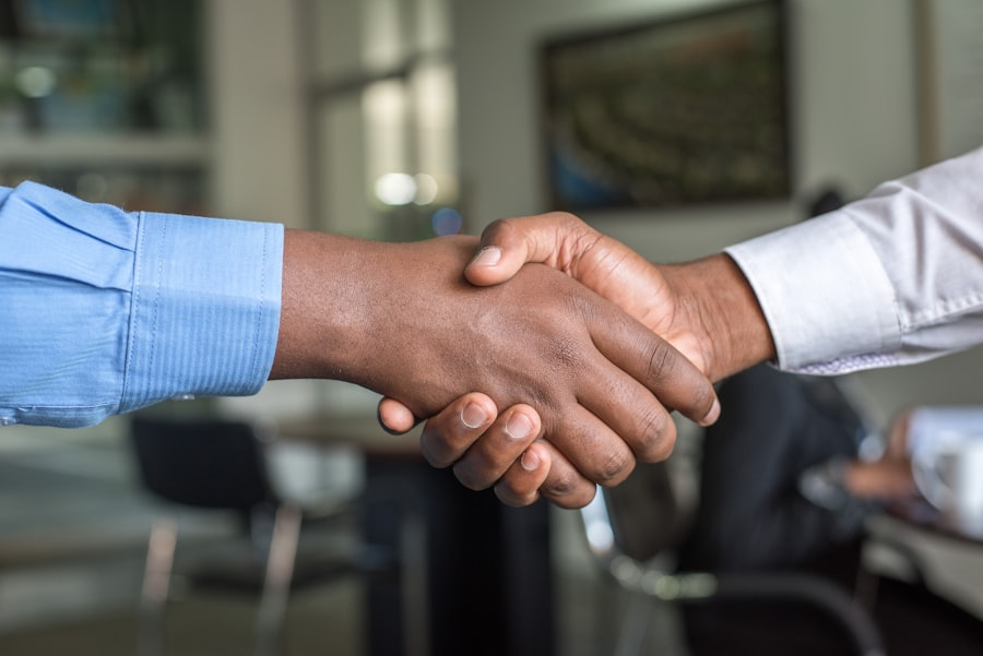 Business partners shaking hands over a desk